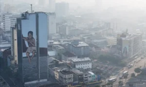 A drone view shows a mural on a building as smoke from Amazon wildfires and a burning landfill hangs over Manaus, Brazil, October 8, 2026. REUTERS/Bruno Kelly