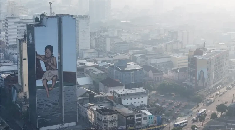 A drone view shows a mural on a building as smoke from Amazon wildfires and a burning landfill hangs over Manaus, Brazil, October 8, 2026. REUTERS/Bruno Kelly