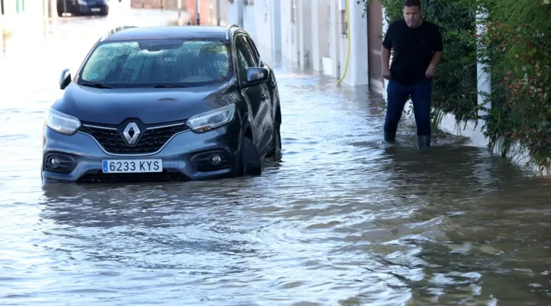 A man walks in a flooded street, following torrential rain, in Oliva, Valencia province, Spain, October 20, 2026. REUTERS/Eva Manez