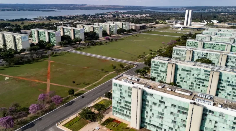 22/06/2026 - Brasília - A floração dos ipês-roxos transforma a paisagem de Brasília em um espetáculo de cores que dura apenas algumas semanas, mas deixa marcas na memória durante todo o ano. Considerada uma das árvores mais simbólicas do Cerrado brasileiro, o ipê anuncia a chegada da estação seca justamente quando perde suas folhas e exibe flores em tons vibrantes que contrastam com o céu azul da Esplanada dos Ministérios. Em meio às linhas retas, ao concreto aparente e aos tons cinza característicos da arquitetura modernista idealizada por Oscar Niemeyer, os ipês surgem como protagonistas da paisagem urbana. A explosão de flores roxas quebra a monotonia das formas e colore avenidas, parques e áreas residenciais, criando uma das cenas mais marcantes da capital federal. Breve e intensa, a floração dos ipês lembra que alguns dos mais belos espetáculos da natureza são também os mais passageiros. Foto: Rafa Neddermeyer/Agência Brasil